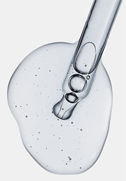 Dropper with puddle of clear liquid.