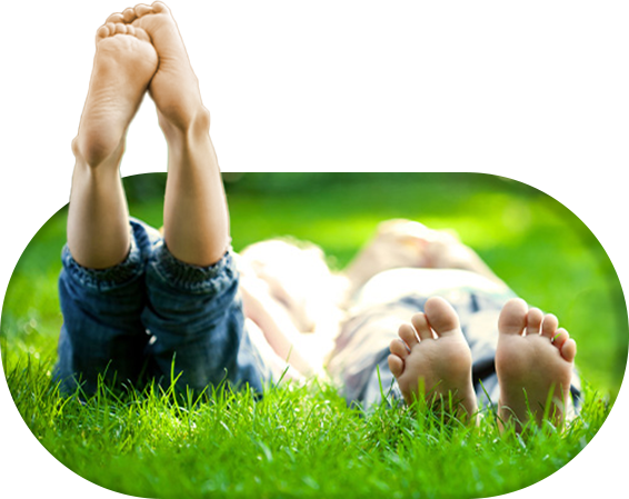 Kids lying on grass with bare feet up in the air.